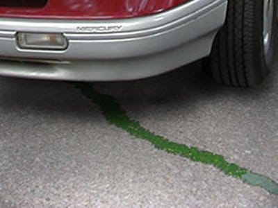 Green coolant antifreeze leaking under car.