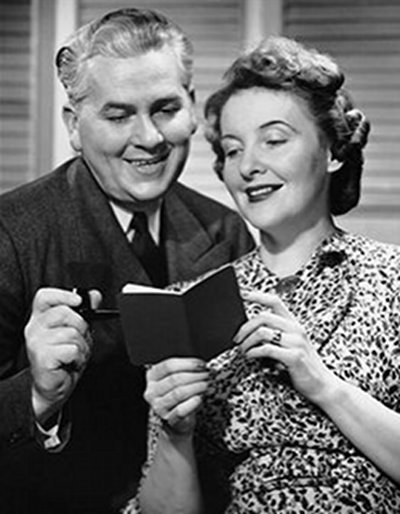 Vintage man and woman looking at bank book pocket notebook.