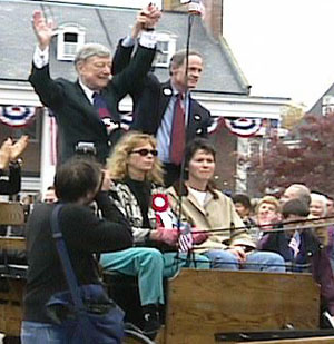 A men holding hands and rising arms and woman's on stage.