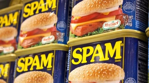 A low-cost can of spam sits on a shelf.