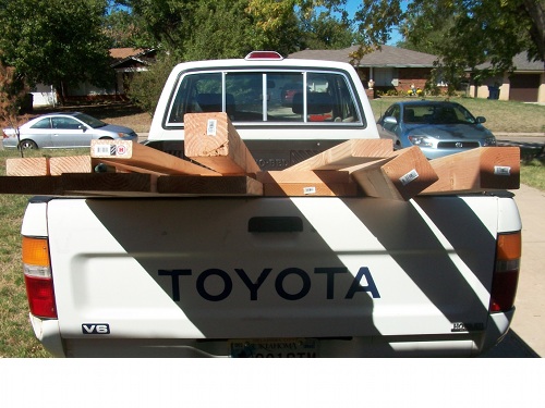 Wood lumber pieces placed in back of toyota car. 