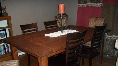 A Thanksgiving dining room table with four chairs and a bookcase.