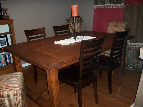 A Thanksgiving dining room table with four chairs and a bookcase.