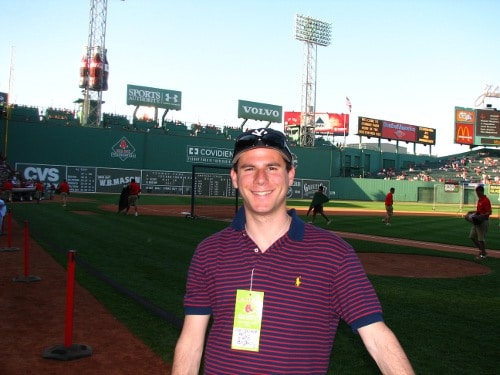 Man giving pose in front of baseball pitch.