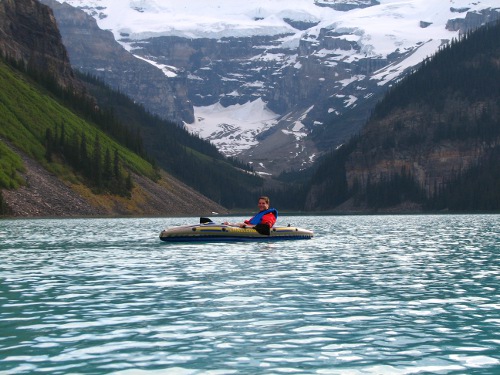 Man travelling in boat at mountain lake.