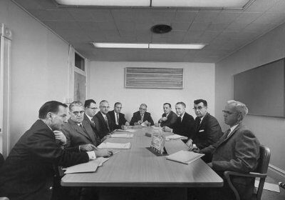A group of men pitching ideas around a conference table.