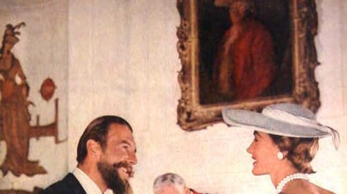 A characteristics man and woman sitting at a table talking.