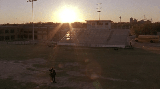 Coach standing in the middle of field.