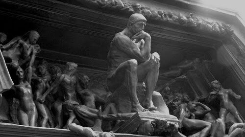 A black and white photo of a statue of the thinker, embodying manliness and contemplating life's lessons.