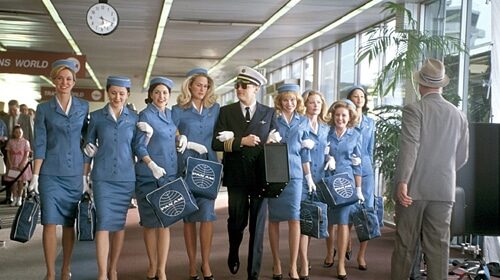 A group of women in blue uniforms expertly handle their way through an airport, leaving no doubt that they are professionals in their field.