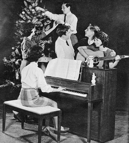 Vintage family decorating christmas tree and singing.