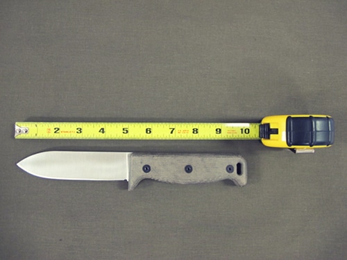 Measuring large survival knife with measurement tape.