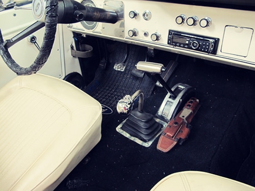 Survival knife in leather holster on floor of car.