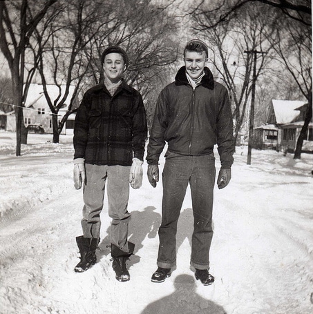 Two men, following the man's guide, standing in the snow, showcasing appropriate cold weather dressing.