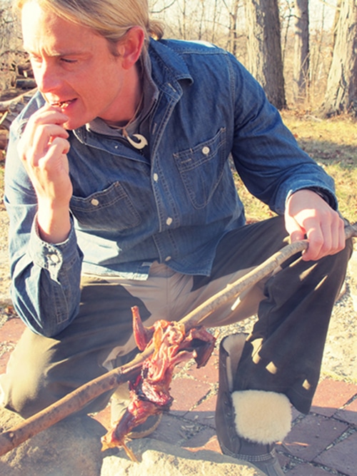 Man eating the cooked squirrel.