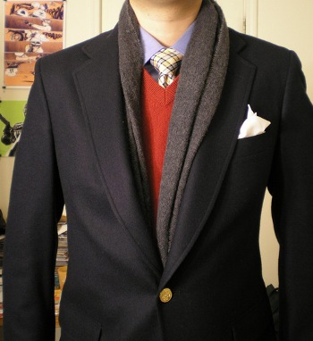 Man wearing scarf under suit coat layering with vest. 