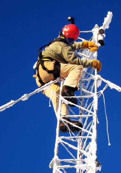 Man working on tower covered with ice.