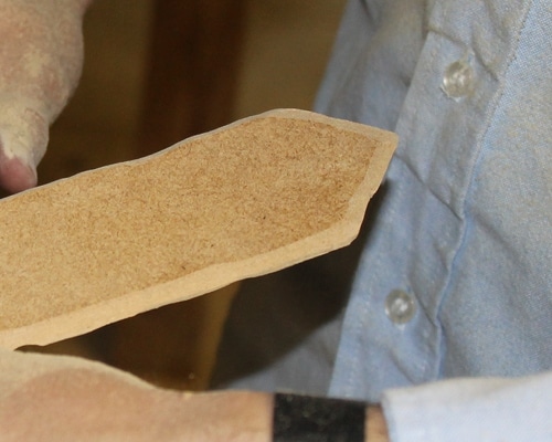 Sanding the side of the blade at an angle to look sharp.