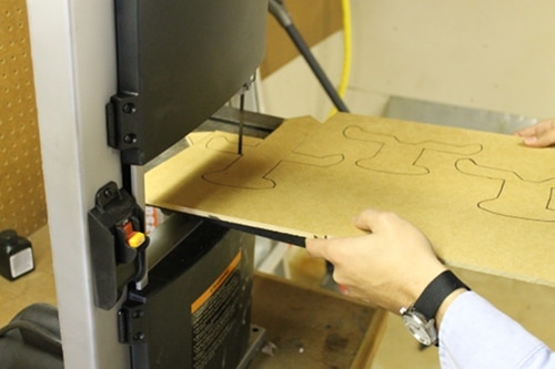 A man cutting the pattern with bandsaw.