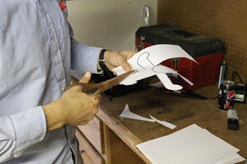 A man cutting a pattern with scissor.