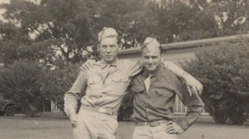 Two men in military uniforms posing for a Manvotional.