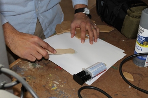 A man putting glue hilts Onto Main Sword.