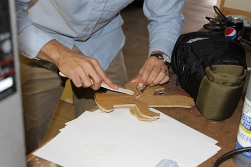 A man applying epoxy to the hilts and attaching them to the main sword.