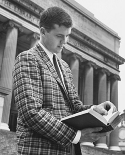 Vintage man in checkered blazer looking at book. 