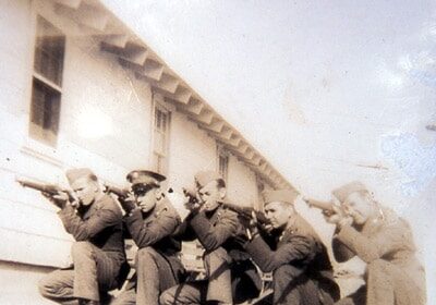 A group of men in uniform, who have just completed their basic training, posing for a photo.