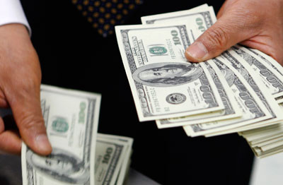 Man counting stack of hundred dollar bills.