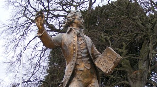 A statue of a man holding a book, symbolizing a personal manifesto.