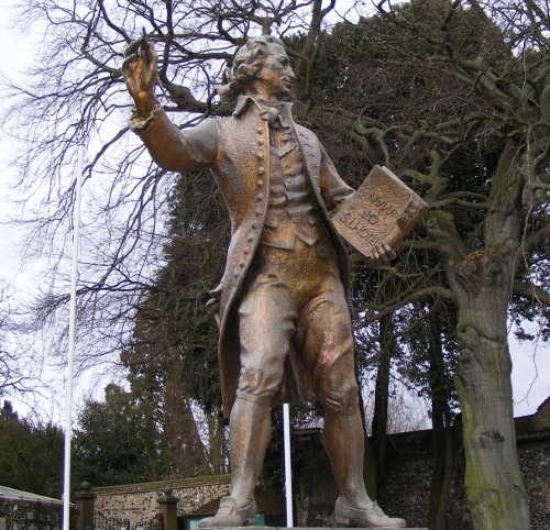 A statue of a man holding a book, symbolizing a personal manifesto.