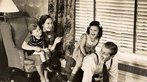 A black and white photo capturing the importance of family, as kids engage in playful roughhousing on a rug.