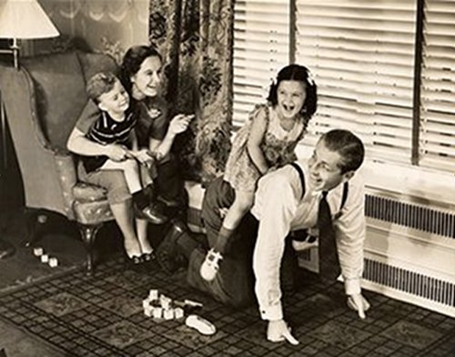 A black and white photo capturing the importance of family, as kids engage in playful roughhousing on a rug.