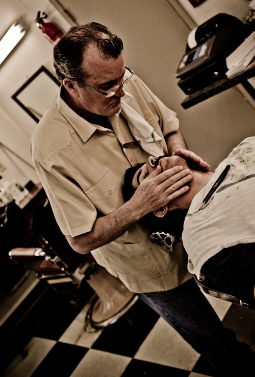 Barber massaging on man's face.