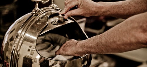 Barber placing towel in gas warmer.