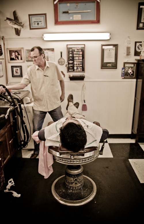 Man lying on the barber bench for shaving.