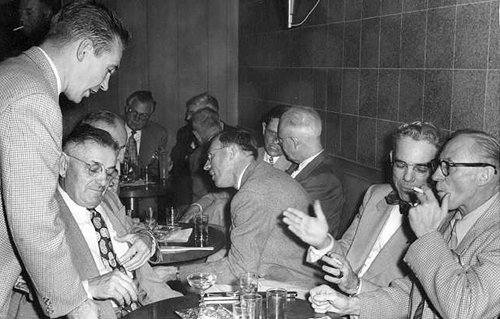 Vintage men sitting and enjoying at lunch table. 