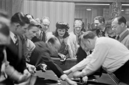 Vintage crowd playing casino around table. 
