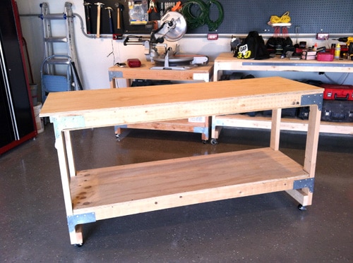 An all-purpose workbench in a garage with tools on it.