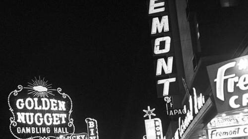 A black and white photo of a neon-lit street.