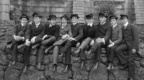 A group of men sitting on a stone wall in post-Civil War America.
