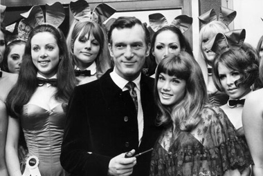 Hugh Hefner giving pose with women models. 