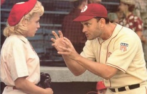 Man coaching baseball tricks to his student in a League of Their Own.