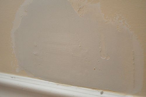 Applying second layer of compound on drywall.