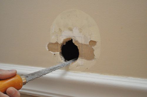 A person patching a hole in a drywall.