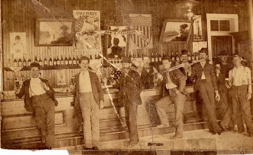 Vintage men posing in front of bar. 