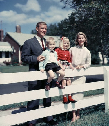 Family standing near fence portrait. 