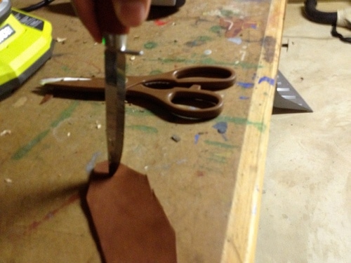 Vintage creating two holes at each of the longest ends of leather strip.