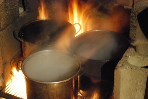 Heating the bucket sap for making syrup.